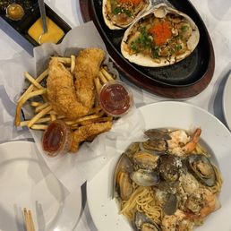 Clams, mussels over garlic noodles, fish n chips - fried potatoes. Clams, mussels over garlic noodles, fish n chips - fried potatoes.