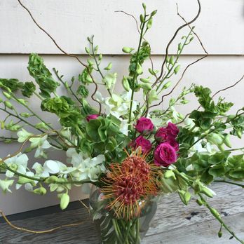 Poppy Jade Studios - orchids, spray roses, and pin cushion protea in a glass vase - Floral Designers Near Me Poppy Jade Studios - orchids, spray roses, and pin cushion protea in a glass vase - Floral Designers Near Me