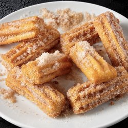 Fuego Cravings - Golden, filled bite-sized churros coated in cinnamon sugar, served with your choice of dip.