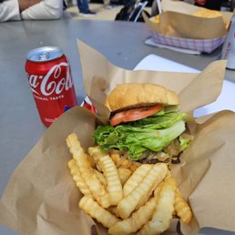 BYOB( build your own burger), toppings include tomato, lettuce, pickles, mayo, and ketchup w/ a side of fries.