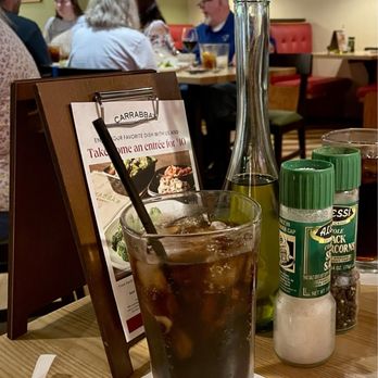 Carrabba's Italian Grill - Part of our table with the oil, salt, pepper, my drink and small menu board - Italian Near Me - Southport, Indiana Carrabba's Italian Grill - Part of our table with the oil, salt, pepper, my drink and small menu board - Italian Near Me - Southport, Indiana