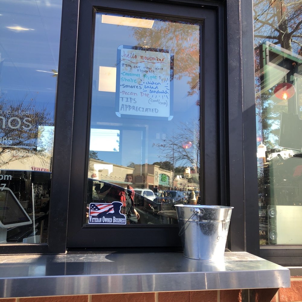 Ellianos Coffee - a cup of coffee in front of a window - Coffee & Tea Near Me - Lithia Springs, Georgia Ellianos Coffee - a cup of coffee in front of a window - Coffee & Tea Near Me - Lithia Springs, Georgia