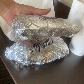 El Nuevo Tlaquepaque - a hand holding a sandwich wrapped in aluminum foil - Mexican Near Me - Exeter, California