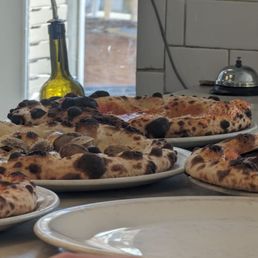 Pizza coming out of the brick oven.