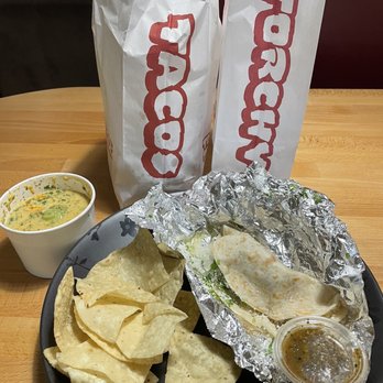 Torchy's Tacos - Chips and green chili queso along with a pork and green chili taco - Tex-Mex Near Me - Richardson, Texas Torchy's Tacos - Chips and green chili queso along with a pork and green chili taco - Tex-Mex Near Me - Richardson, Texas