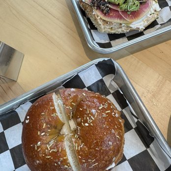 Bagelshop - Donelson - Two bagel dishes, inside. Left is a rosemary sea salt bagel with plain vegan schmear. The other is their R.A.D. Tartine open-face bagel. - Coffee & Tea Near Me - Nashville, Tennessee