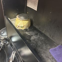 Salon Image - "Condition of storage area beside the shampoo bowl."