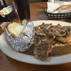 Boneless pork chops with baked potato and mushroom gravy.