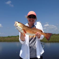 REEL Screamers Guide Service - A happy lady with a beautiful Redfish