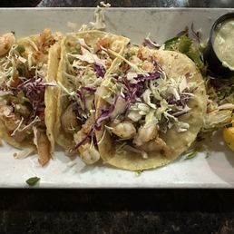 Tacos De Camaron- three shrimp tacos on corn tortillas with a side of slaw. Tacos De Camaron- three shrimp tacos on corn tortillas with a side of slaw.