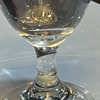 Sambou’s African Kitchen - Glass of water with illumination of the chandelier looking as if gold lies awaiting - African Near Me - Jackson, Mississippi