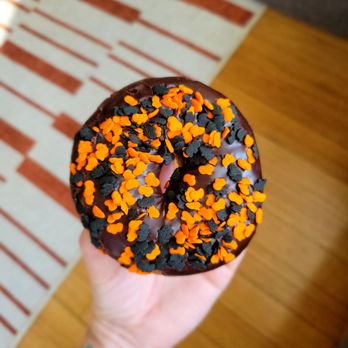 Somethin' Sweet Donuts -  hand holding a chocolate donut with sprinkles - Donuts Near Me - Chicago, Illinois