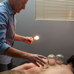Inner Gate Health & Wellness - Acupuncturist Casey McGuire performing cupping therapy to reduce pain and muscle tension for shoulder and back pain.