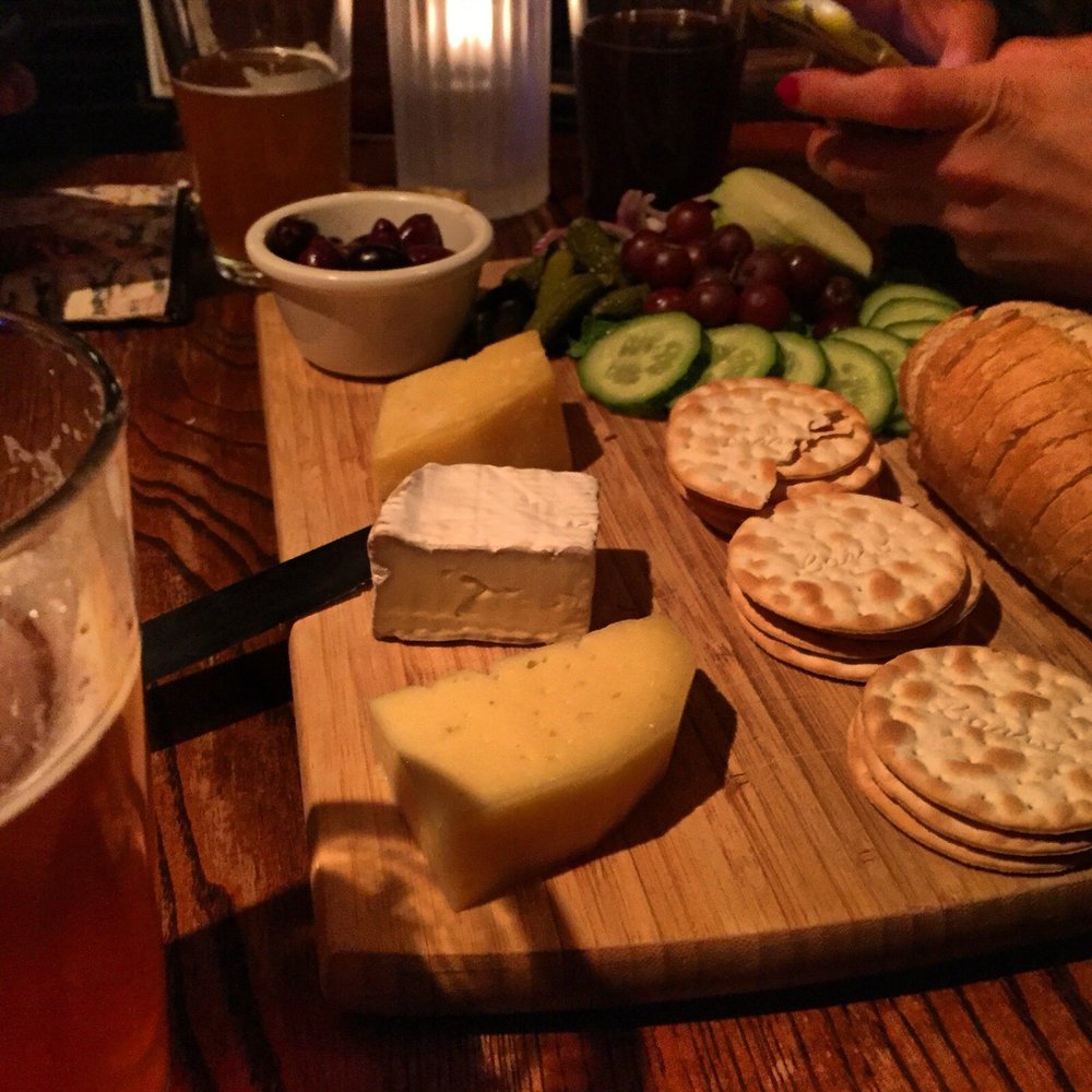 Dubliner - a cheese board with crackers, grapes, cucumbers, and bread - Irish Near Me - Dallas, Texas