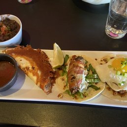 Birria, bacon wrapped jalepeno and chorizo and egg taco with a side of vegan black beans.
