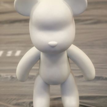 Crafts Zone Studio - A smooth, white bear-shaped figurine with rounded ears, limbs, and a body, but lacking facial features or other details. It stands upright on a wooden surface with a blurred background, and appears to be made of a matte material, possibly ceramic or plastic. - Paint & Sip Near Me - Brookline, Massachusetts