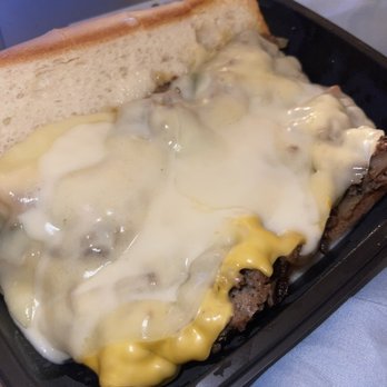 Pardon My Cheesesteak - a person holding a sandwich - Food Delivery Services Near Me Pardon My Cheesesteak - a person holding a sandwich - Food Delivery Services Near Me
