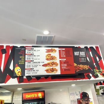 Dave's Hot Chicken - a man standing in front of a menu - Chicken Shop Near Me - Burbank, California Dave's Hot Chicken - a man standing in front of a menu - Chicken Shop Near Me - Burbank, California