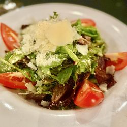 Salvatore G's Italian Restaurant - Mista Mixed greens, roma tomatoes and red onions tossed with our famous Galluzzo's balsamic honey vinaigrette and topped with parmigiano.