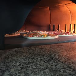 Basilic & Co Voiron - La cuisson de nos pizzas de terroir au four à bois (sur sole de pierre)