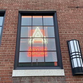 Asylum Distillery - neon sign in window of brick building - Distilleries Near Me - Billings, Montana Asylum Distillery - neon sign in window of brick building - Distilleries Near Me - Billings, Montana