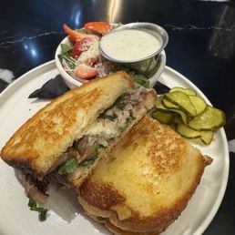 Short rib melt with a side salad and pickles Short rib melt with a side salad and pickles