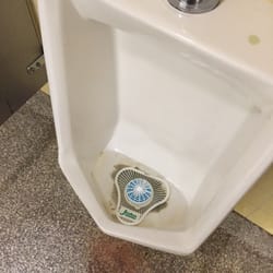 Brown stuff at the bottom of the urinal. Obviously not cleaned in months for this type of build up to occur. Yuck.
