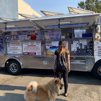 Tacos El Autlense - a woman and her dog standing in front of a food truck - Mexican Near Me - Albany, California Tacos El Autlense - a woman and her dog standing in front of a food truck - Mexican Near Me - Albany, California