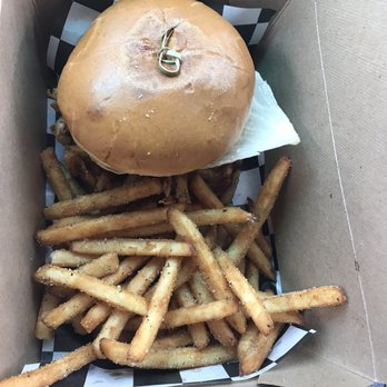 The Ranch Hand - Ranch burger and regular fries. - A burger with a bun and a keyring on top, accompanied by seasoned French fries in a cardboard takeout container. - Food Trucks Near Me - Chico, California