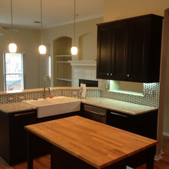 JD Remodeling Co - a kitchen with black cabinets and a white sink - General Contractors Near Me