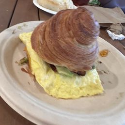Breakfast sandwich on croissant with bacon & avo.