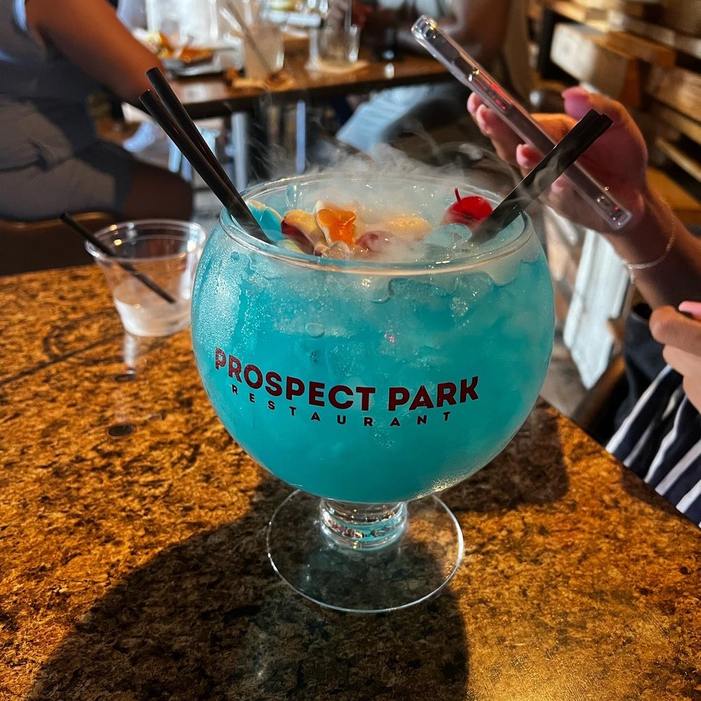 Prospect Park - a blue drink in a glass on a table - Sports Bars Near Me - Houston, Texas Prospect Park - a blue drink in a glass on a table - Sports Bars Near Me - Houston, Texas