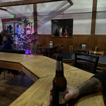 Camp Union Saloon - a person holding a bottle of beer - Bars Near Me - Seabeck, Washington