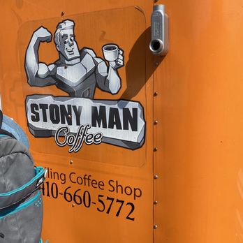 Stony Man - a man holding a cup of coffee - Donuts Near Me