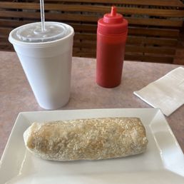 Breakfast burrito with a large drink. Breakfast burrito with a large drink.