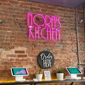 Nora's Kitchen - a brick wall with a neon sign - Mexican Near Me - Philadelphia, Pennsylvania