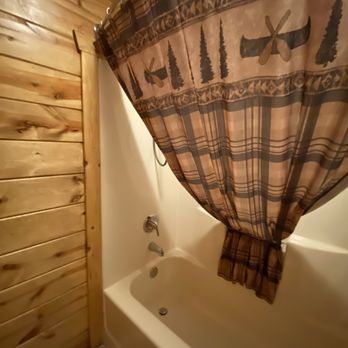 Frontier Cabins - Bath tub with a cabin-y shower curtain - Guest Houses Near Me - Wall, South Dakota