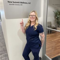 New Summit Wellness - Nurse Casey in front of the New Summit Wellness clinic sign