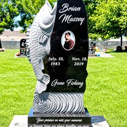 Custom fishing-themed headstone honoring Brian Massey with polished black granite, custom engraving, and memorial artwork.