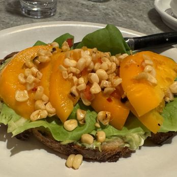 Tonic - Open-faced tomato sandwich with smashed avocado, feta, and roasted corn salad. - New American Near Me - Charlottesville, Virginia