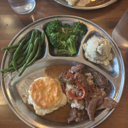 Sunday dinner plate with beef tips, mashed potatoes, and green vegetables.