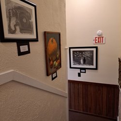 The Rosewater - Paintings on the wall leading to the upstairs. Upstairs there is a children section, mystery, and romance books.