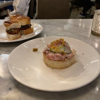 Third Coast Provisions - Ahi tuna tartare on crispy rice in the foreground and oyster sliders in the background - New American Near Me - Milwaukee, Wisconsin Third Coast Provisions - Ahi tuna tartare on crispy rice in the foreground and oyster sliders in the background - New American Near Me - Milwaukee, Wisconsin