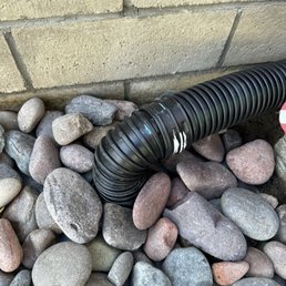Connected gutter downspout to drainage under the block wall down the slope.