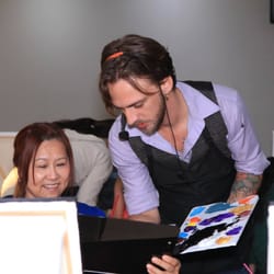 Bamboo Studio - One of our instructors, Joshua, helps a painter with mixing colors on her palette.