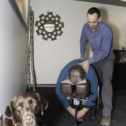 Community Chiropractic - Dr. Sam adjusting a patient and getting some support from Nugget, the office mascot!