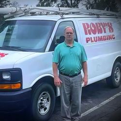 Roby's Plumbing - Owner smiling in front of the Roby's Plumbing truck, representing our dedication to quality service.