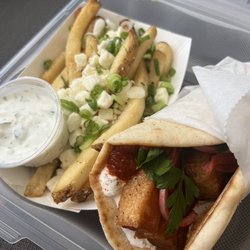 Greek Street Food Truck - Pork belly gyro with greek-street tzatziki, tomato jam, parsley, pickled red onions, and paprika. Side of Greek fries with tzatziki sauce.