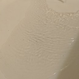 Hard to tell because of the light in the bathroom, but those are dirt particles in the ice cold water in which I had to shower