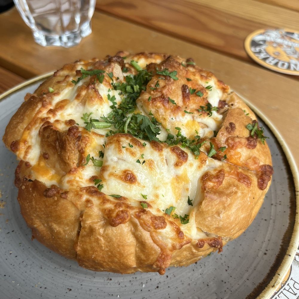 Steamworks - a close up of a pizza on a plate - Breweries Near Me - Vancouver, British Columbia
